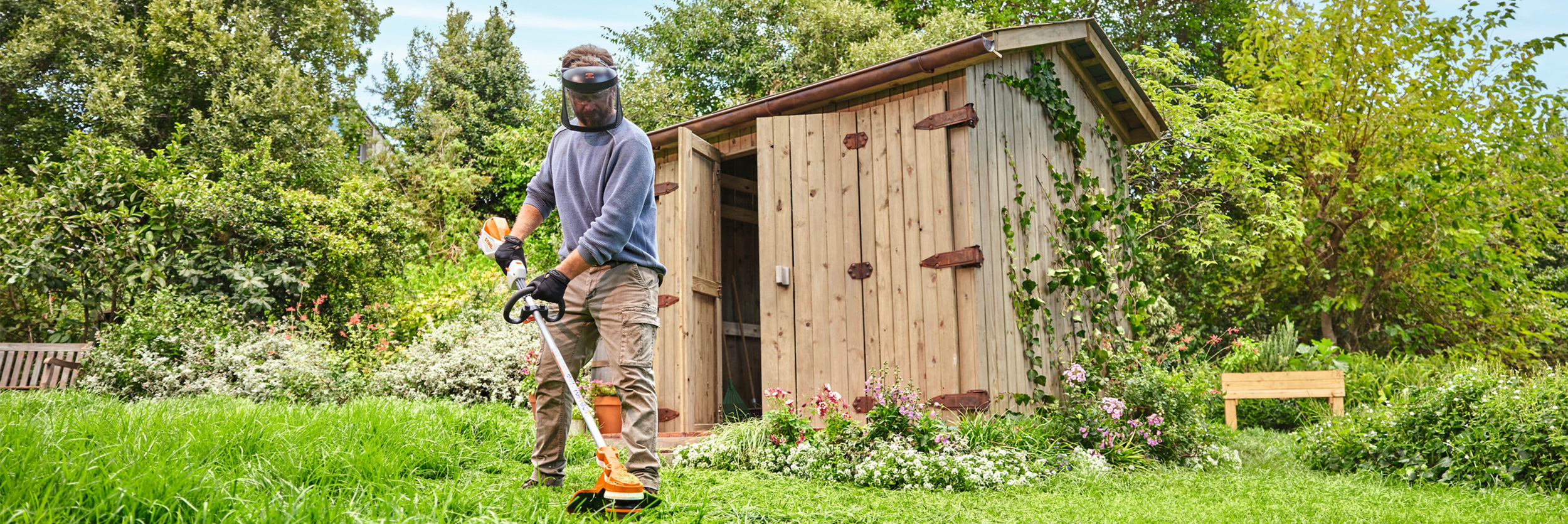  Mężczyzna przycinający trawę akumulatorową kosą mechaniczną STIHL FSA 70 R