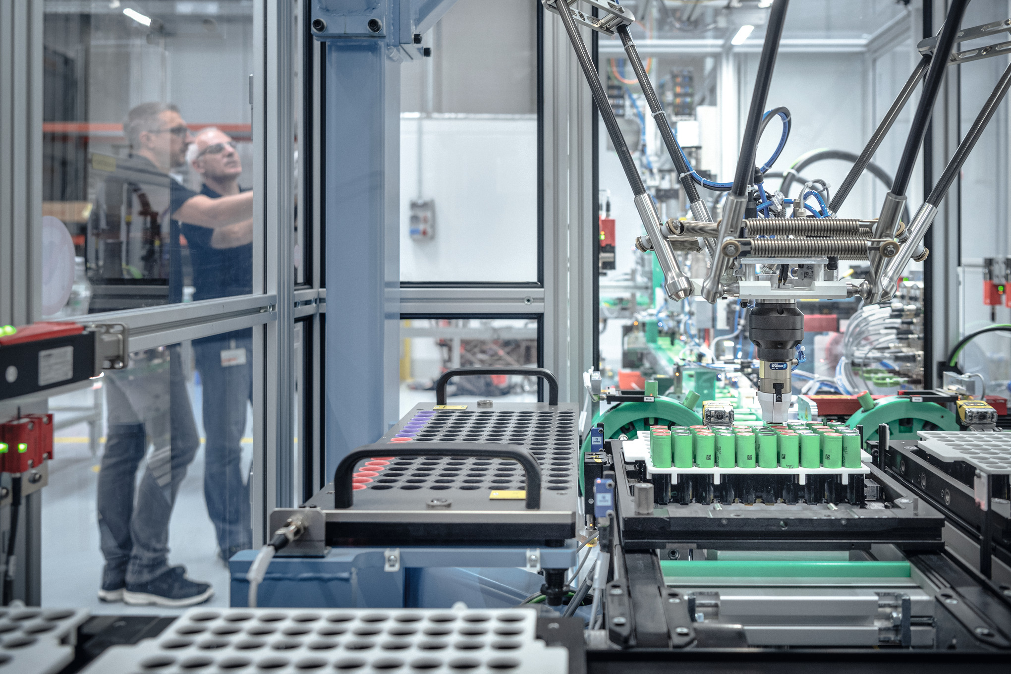 Dwóch mężczyzn produkujących akumulatory STIHL w otoczeniu maszyn i robotów