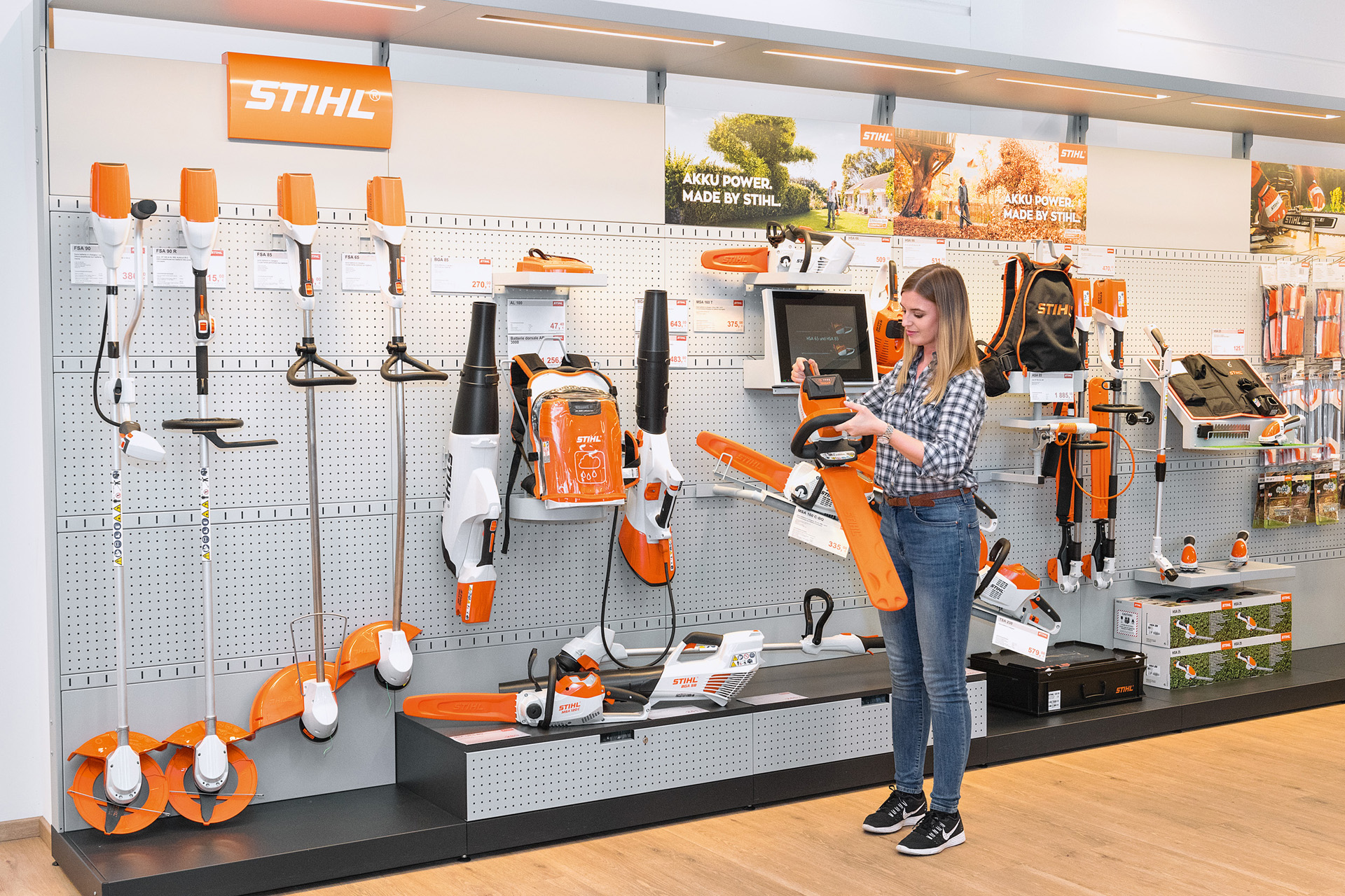 Młoda kobieta przy ladzie u Autoryzowanego Dealera STIHL chce bezpłatnie wypróbować pilarkę STIHL