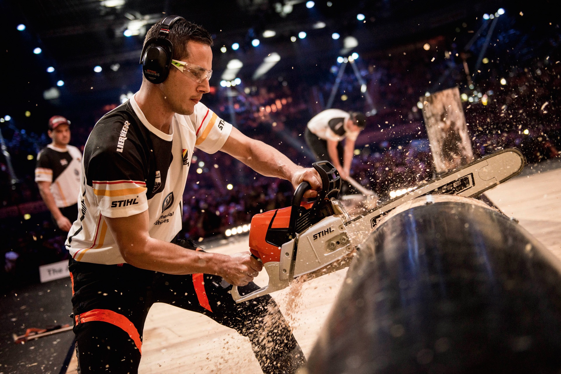 Sportowiec STIHL TIMBERSPORTS® tnący pień drzewa w zawodach 
